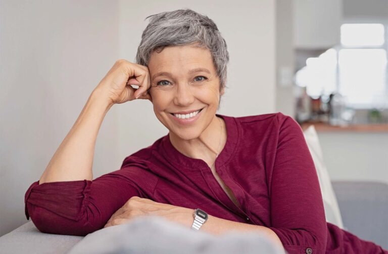 older woman sitting on the couch smiling